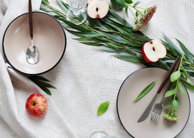 Masa takımı. Tabaklar masada, armut ve çatal bıçak takımı var..