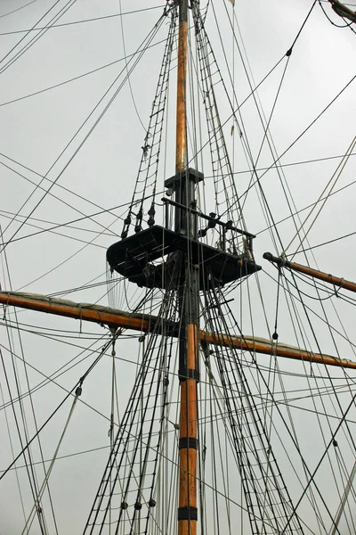 帆船木桅杆和具灰色天空背景的梯子和绳索的装备 — 图库照片