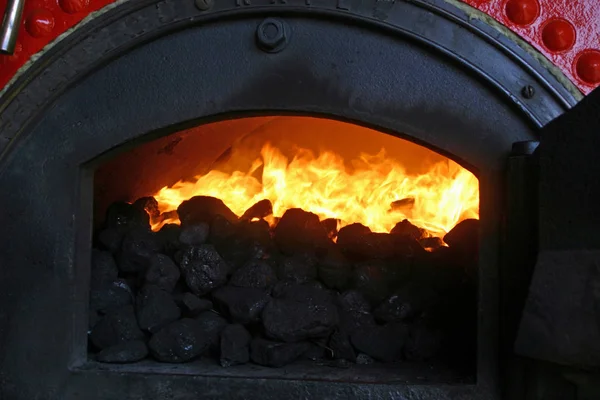 Yanan kömür parlak alev ve duman bir buhar motoru kazan.