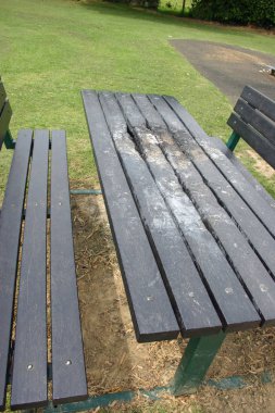 Hurdalığın yeşil metal ve siyah plastik piknik tezgah üstünde belgili tanımlık tepe ateşe ayarlamak geri dönüştürülmüş. Arka plan çim çim.