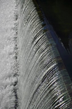 Weir için sola doğru ve çalkantılı su durgun su ile üzerinden akan su.
