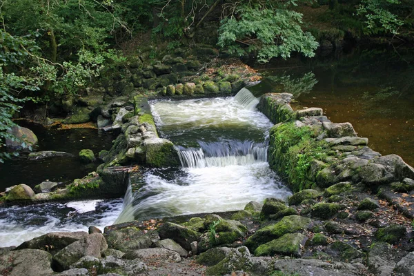 双堰在两个相连的水池和水之间流动的河流 四周环绕着岩石和树木 — 图库照片