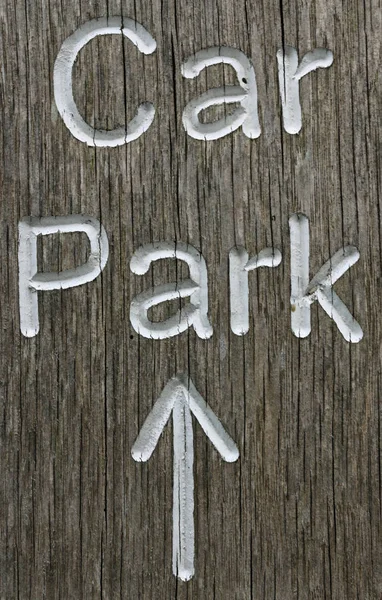 质朴的停车场方向标志传送到细粒度的木材和白色字母拼写的单词停车场和指向顶部中心的白色箭头 — 图库照片