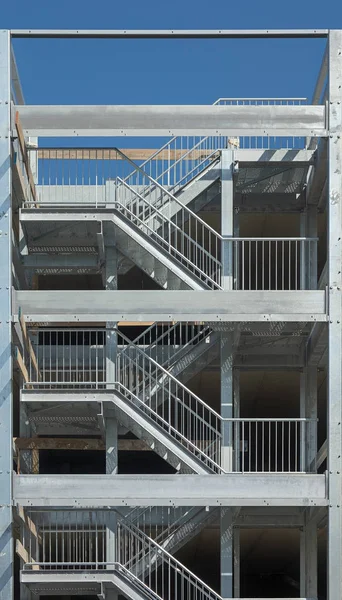 A steel staire case a the side of a parking garage serving as a safe route fire escape