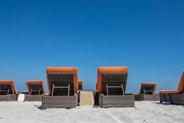 Καρέκλες και ομπρέλα σε μια παραλία κοντά στη θάλασσα. — Φωτογραφία Αρχείου