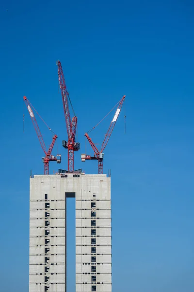 Múltiples grúas torre sobre una estructura de hormigón . — Foto de Stock