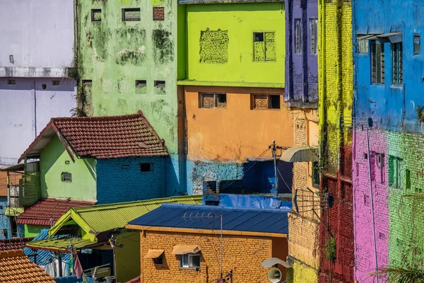 brightly colored facades and roofs of houses in a neighborhood of Malang, Indonesia.