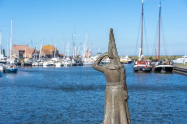 Hollanda 'nın Friesland kentindeki Stavoren limanındaki ünlü kadın. Arka planda tekneler