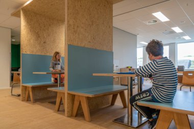 ARNHEM / NETHERLANDS - 28 AĞUSTOS 2020: İlkokuldaki çocuklar grup olarak çalışırlar. Modern bir okul binasındalar.