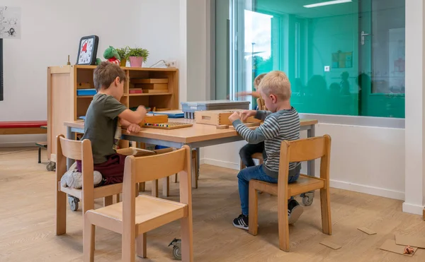 ARNHEM / NETHERLANDS - 28 Ağustos 2020: Anaokulundaki çocuklar oyuncaklarla oynuyorlar. Dolaplarda, kutularda ve kasalarda depolanan diğer oyuncaklar.