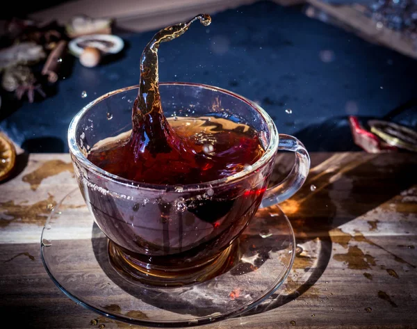 Tasse Tee Mit Spritzer Auf Dunklem Holzhintergrund — Stockfoto
