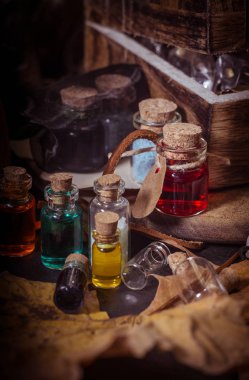 Sihirli kavramı. Şişeler, mumlar, kutu ve turuncu yaprak iksir. Büyülü arka plan