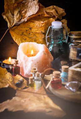 Sihirli kavramı. Şişeler, mumlar, kutu ve turuncu yaprak iksir. Büyülü arka plan