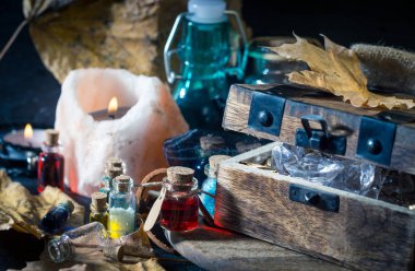 Sihirli kavramı. Şişeler, mumlar, kutu ve turuncu yaprak iksir. Büyülü arka plan