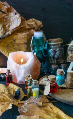 Sihirli kavramı. Şişeler, mumlar, kutu ve turuncu yaprak iksir. Büyülü arka plan