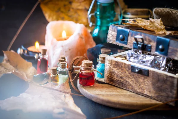 Sihirli kavramı. Şişeler, mumlar, kutu ve turuncu yaprak iksir. Büyülü arka plan