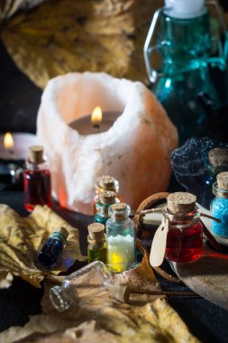 Sihirli kavramı. Şişeler, mumlar, kutu ve turuncu yaprak iksir. Büyülü arka plan