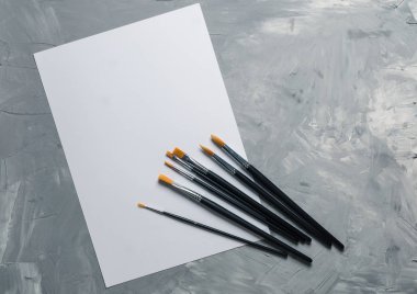 Resim brusches, gri beton zemin üzerine beyaz kağıt. Düz yatıyordu, en iyi görünümü