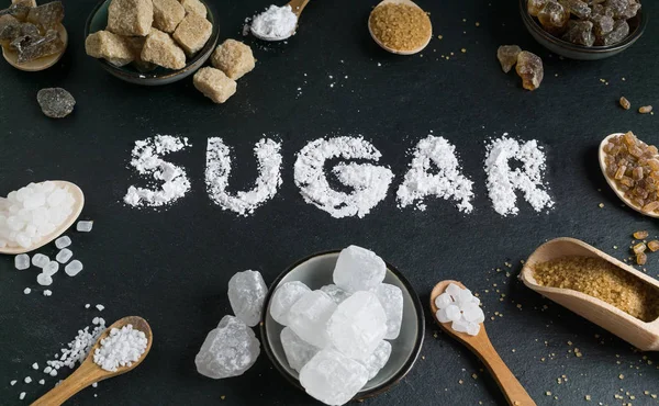 糖变异设置在黑暗的石头背景以词糖 褐色和白色 水晶和甘蔗糖 — 图库照片