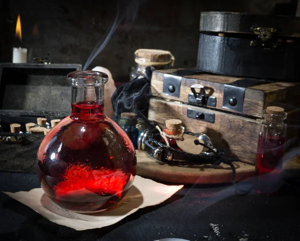 Sihirli kavramı. Şişeler, mumlar, kutu ve turuncu yaprak iksir. Büyülü arka plan