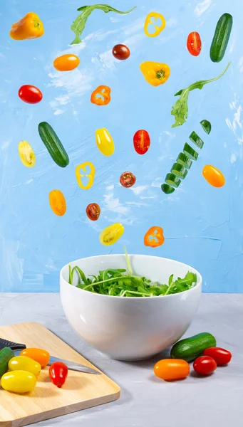 Schwebend Gemischtes Gemüse Auf Blauem Hintergrund Magische Gurken Tomaten Und lizenzfreie Stockfotos