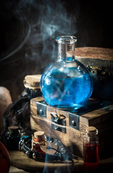 Blue magic potion with smoke. Magical concept with wooden box, Dark magic concept