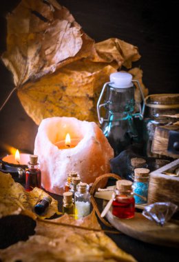 Sihirli kavramı. Şişeler, mumlar, kutu ve turuncu yaprak iksir. Büyülü arka plan