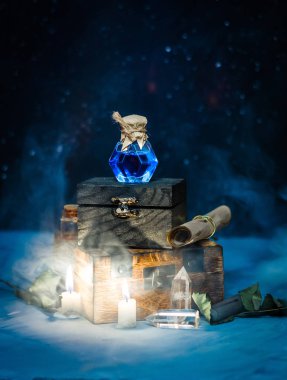 Blue magic potion with smoke, candles, star sky on wooden box. Dark magic concept clipart