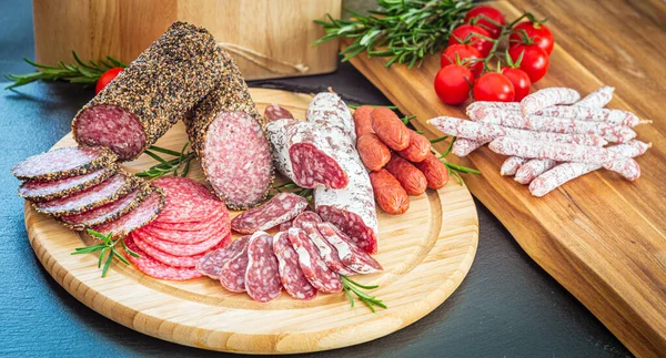 Tahta tabakta dilimlenmiş İtalyan domuz salamı.