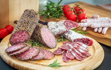 Tahta tabakta dilimlenmiş İtalyan domuz salamı.