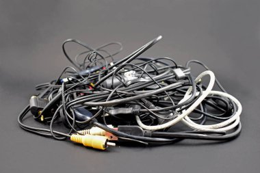 Karışık kablolar ve konektörler hazır görüntüler. Kablolar siyah bir arka plan üzerinde arapsaçı. Plastik elektronik atık