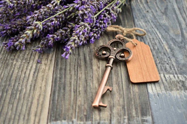 Old key with lavender stock photo images. Lavender on a wooden background. Decorative metal key images. Romantic key with wooden label. Key on the table