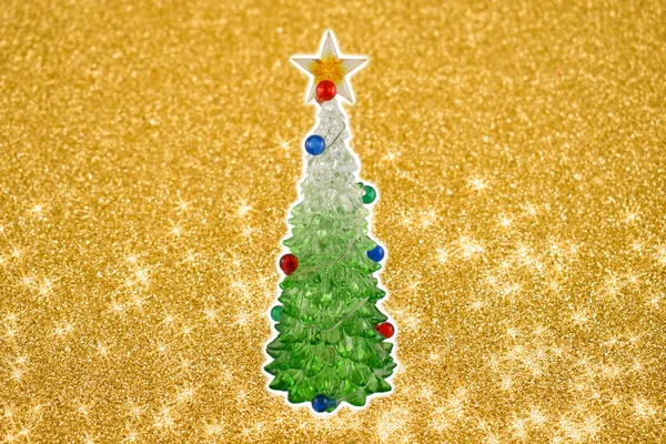 Golden christmas background with a tree stock images. Simple Christmas card. Christmas decoration on a golden background. Christmas tree with a star. Holiday background with copy space for text