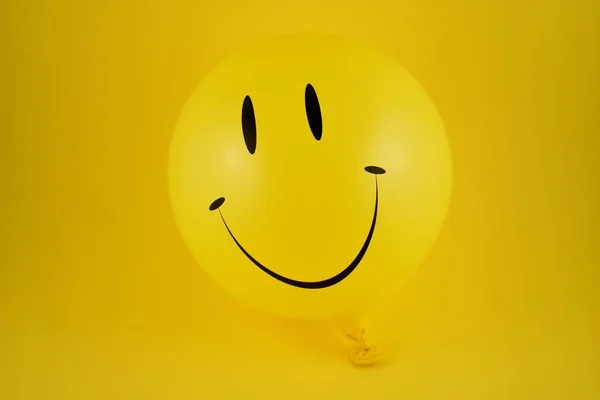 Happy emoji balloon stock images. Yellow balloon stock images. Smiley inflatable balloon isolated on yellow background. Laughing party balloon