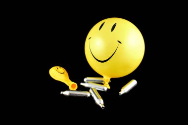 Gülme gazı balonlar hazır görüntüler. Mutlu emoji balon hazır görüntüler. Gülen şişme balon bir siyah arka plan üzerine izole. Parti Balon gülüyor. Gülme gazı bombaları hazır görüntüler