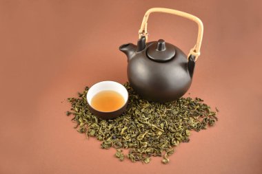 Seramik çaydanlık bardak stok fotoğraf ile. Kahverengi zemin üzerine yeşil çay. Gevşek yeşil çay. Çin çay bardağı. Kahverengi çay seti. Gevşek çay