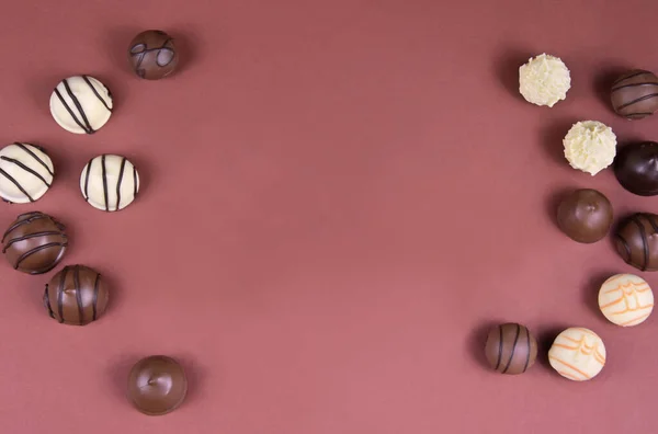 チョコレートプラリネフレームトップビューストック画像 茶色の背景にチョコレートキャンディ チョコレートのフレームトップビュー チョコレートはテキストのためのコピースペースが付いている背景を原理化する キャンディ写真の境界線 — ストック写真