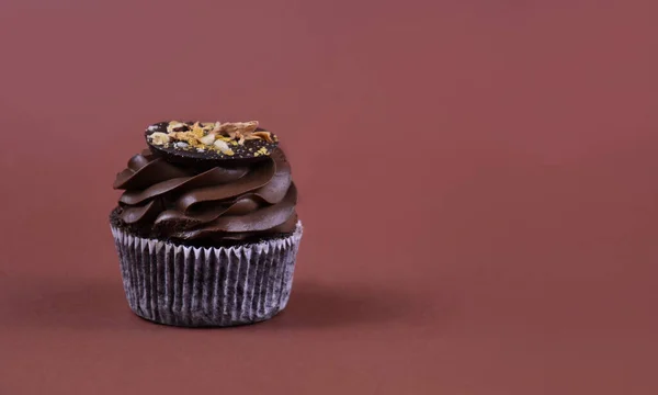 チョコレートクリームカップケーキブラウンフレームストック画像 チョコレートカップケーキは テキスト用のコピースペースと茶色の背景に隔離されています おいしいカップケーキのストック画像 チョコレートカップケーキブラウンの境界線 — ストック写真