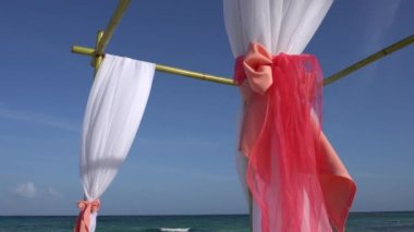 Düğün kemer tropik sahilde büyük rüzgar gelişmekte olan kumaşlar ile dekore edilmiştir. Turkuaz su Karayip Denizi. Riviera Maya Meksika