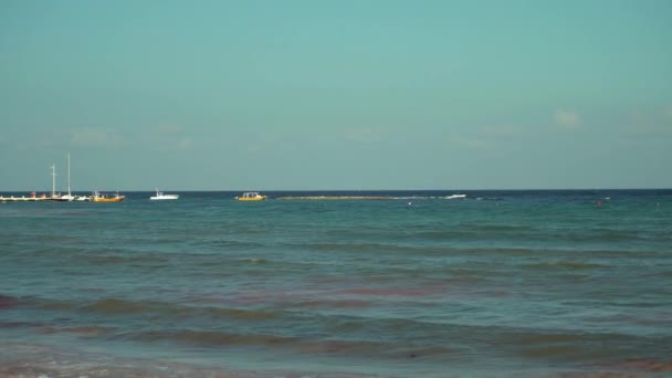 Blick auf den tropischen Strand bei Sonnenuntergang. Parasailing-Boote auf Pier. türkisfarbenes Wasser der Karibik. Riviera Maya Mexiko — Stockvideo