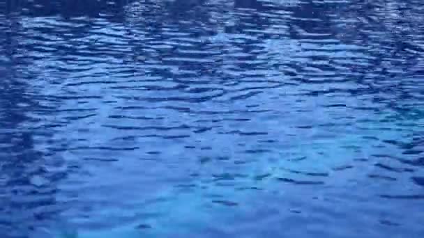 在游泳池中的纯净的蓝色水波浪表面以轻的反射。美丽的背景 — 图库视频影像