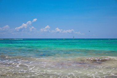 Tropikal plaj manzarası. Turistler ile paraşüt paraşüt tekne yolculuğu. Yelkenli Yat dalgalar üzerinde yola çıkacak. Turkuaz su Karayip Denizi. Riviera Maya Meksika