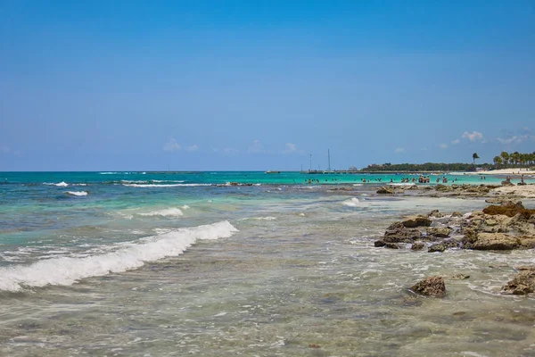 Вид на пляж роскошного курортного отеля на побережье Океании. Листья кокосовых пальм трепещут на фоне синего неба. Бирюзовая вода Карибского моря. Мексика: Ривьера Майя . — стоковое фото
