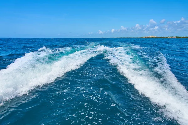 Sentiero sulla superficie dell'acqua dietro di catamarano a motore in rapido movimento nel Mar dei Caraibi Cancun Messico. Estate giornata di sole, cielo blu con nuvole Immagini Stock Royalty Free