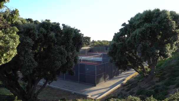Une fille qui joue au tennis. Pepperdine University Tennis Courts. Soirée d'été chaude au coucher du soleil à Malibu Californie USA — Video