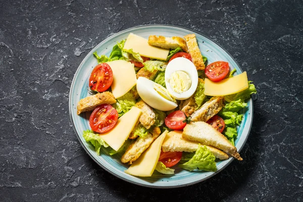 Frisse caesar salade in plaat op zwarte stenen tafel — Stockfoto