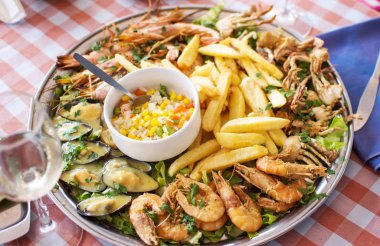 kızarmış deniz ürünleri - yengeç, karides, midye ile kızarmış patates ve pilav.