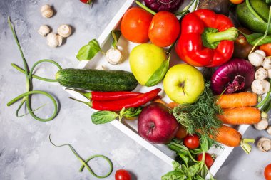 Üstten görünüm beton zemin üzerine beyaz tepsisinde sağlıklı yemek için taze malzemelerle çiğ organik sebze