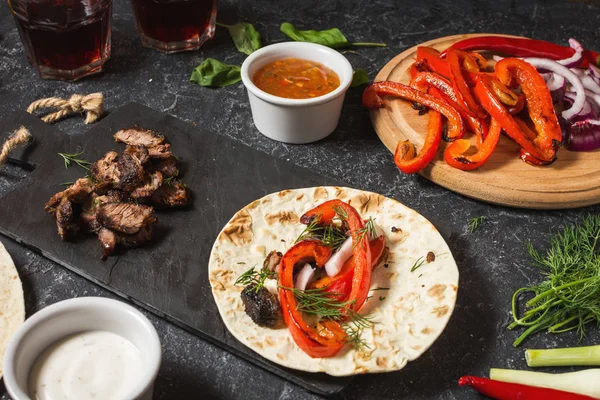 Taze lezzetli Meksika tacos ve gıda maddeleri siyah taş zemin üzerine. Yemek. Üstten görünüm