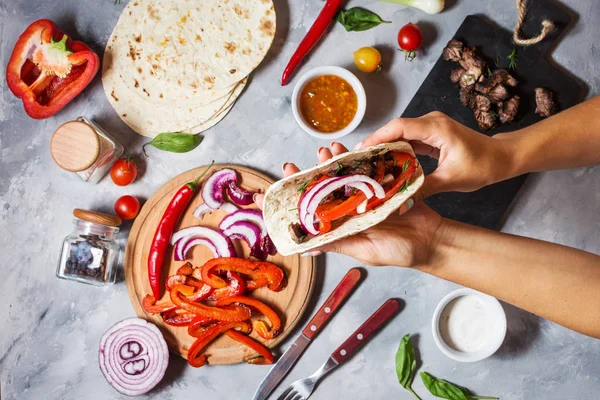 Eller Meksika tacos beton zemin üzerine tutun. Yemek. Üstten görünüm